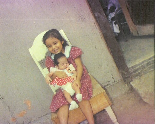 A mexican-american little girl carrying her baby sister to later bond with animal songs